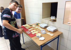 Uczniowie w trakcie przygotowania gorących kanapek.