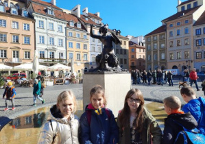 Uczestnicy wycieczki przed pomnikiem Warszawskiej Syrenki