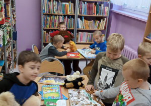 Uczniowie czytający książki o misiach w szkolnej bibliotece