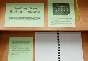 Informacje o Światowym Dniu Braille'a i książka w brajlu wyeksponowane na regale.