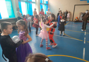 Dzieci w strojach karnawałowych w trakcie zabawy tanecznej.