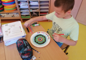 Uczeń tworzy pracę za pomocą kolorowych kółek