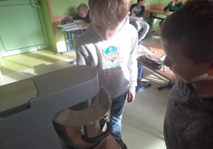 Uczniowie w trakcie obserwacji momentu powstania masła ze śmietany.