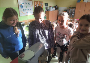 Uczniowie w trakcie obserwacji momentu powstania masła ze śmietany.