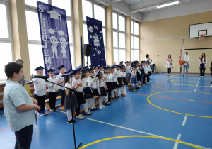 UCZNIOWIE KLAS PIERWSZYCH W TRAKCIE ŚLUBOWANIA NA SZTANDAR SZKOŁY