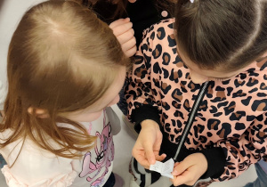 Dzieci oglądające najmniejszą książkę w bibliotece