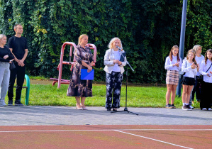 Dyrekcja szkoły witająca społeczność szkolną zgromadzoną na boisku szkolnym