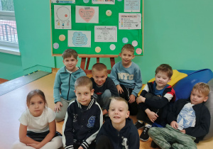 Uczniowie siedzący przy tablicy prezentującej DZIEŃ KROPKI w nasze szkole