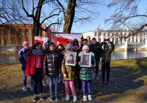 Uczniowie klasy 4a z flagami Polski.