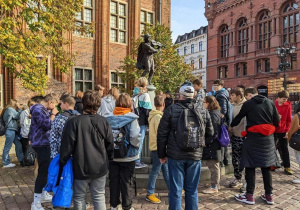 Uczetnicy wycieczki na Starym Rynku pod pomnikiem Flisaka